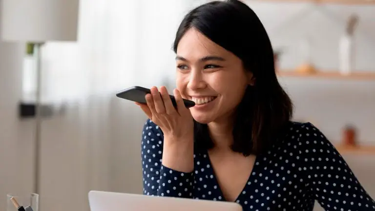 Mulher usa Smartphone para conversar com Chatbot. Assistente virtual versus chatbots: entenda as diferen&ccedil;as